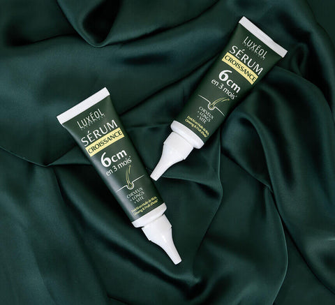 Flat lay of multiple Growth Serum tubes on fabric for range branding