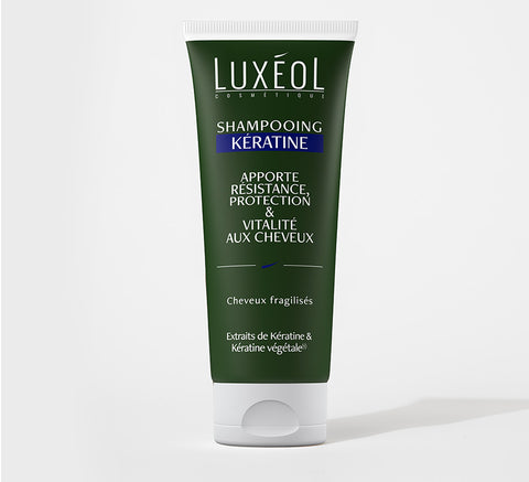 Tube of dark green Luxéol keratin shampoo on white background