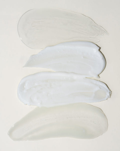 Три мазка белого крема на светло-сером фоне