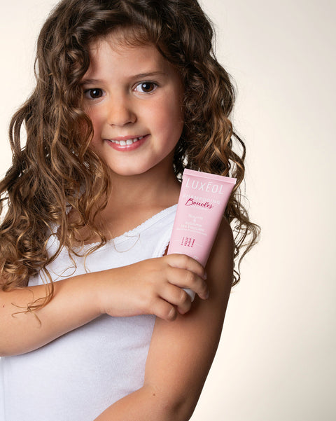 Young girl holding a pink product with a white background