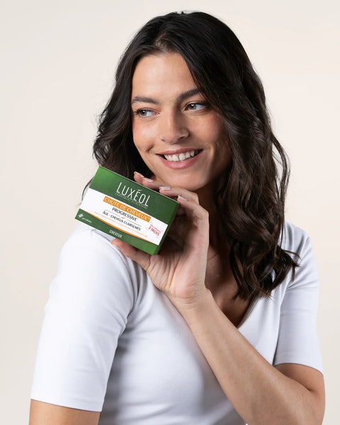 Woman holding a Luxeol product box against a plain background