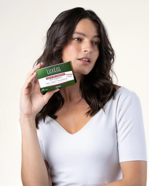 Woman holding a Luxeol product box against a white background